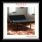 Gray adjustable bed in a room with curtains and a rug, featuring 'Rowes Furniture & Bedding' and 'SleepMaker'.