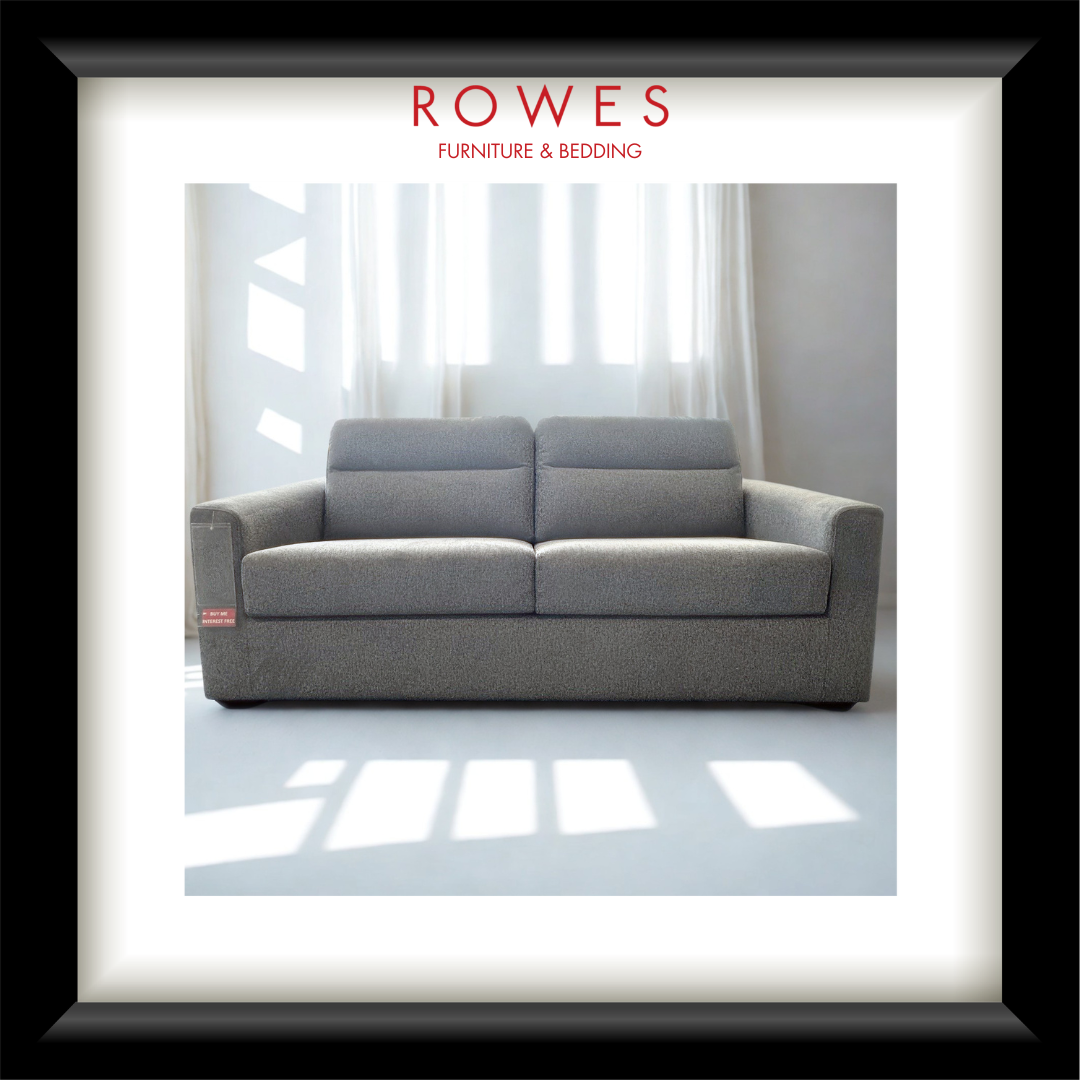 Gray sofa in a room with white curtains, branded as Rowes Furniture & Bedding.
