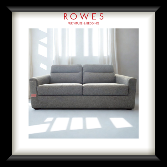 Gray sofa in a room with white curtains, branded as Rowes Furniture & Bedding.