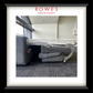Gray sofa with a bed extension in a room, featuring 'Rowes Furniture & Bedding' branding.