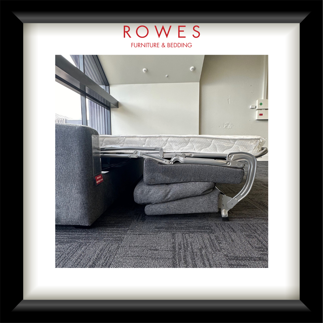 Gray sofa with a bed extension in a room, featuring 'Rowes Furniture & Bedding' branding.