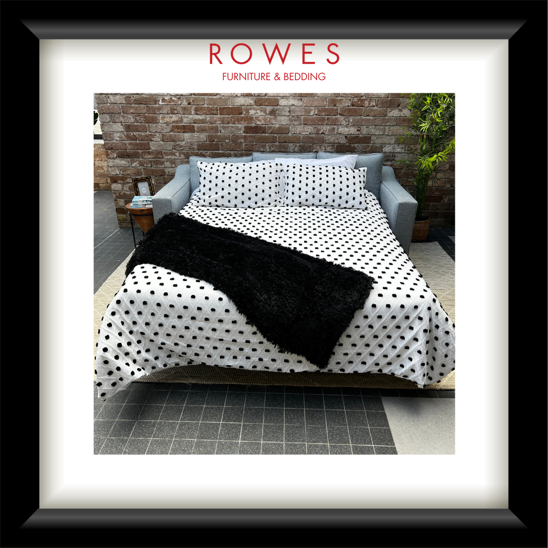 Furniture and bedding set with polka dot pattern on a bed, branded as Rowes Furniture & Bedding.