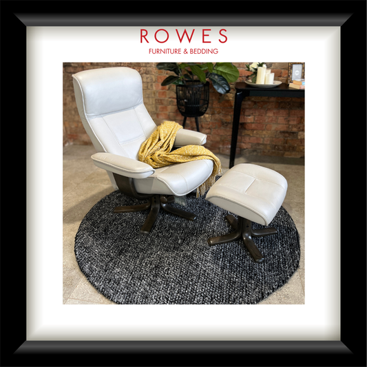 White chair and ottoman with a yellow blanket on a gray rug, branded as Rowes Furniture & Bedding.