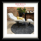 Modern white chair with ottoman on a textured rug in front of a brick wall, with 'Rowes Furniture & Bedding' branding.