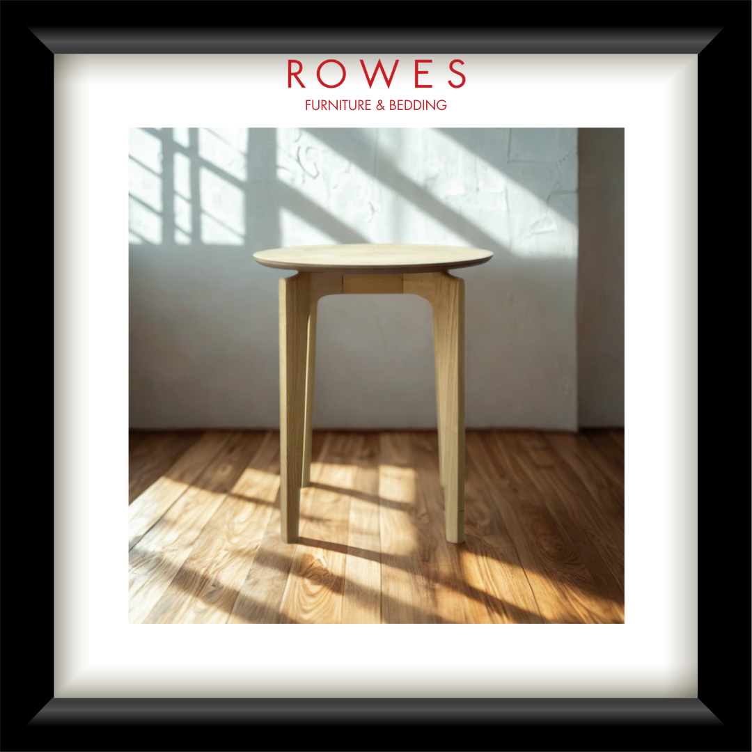 A lamp table in a well lit room on a timber floor with the Rowes branding