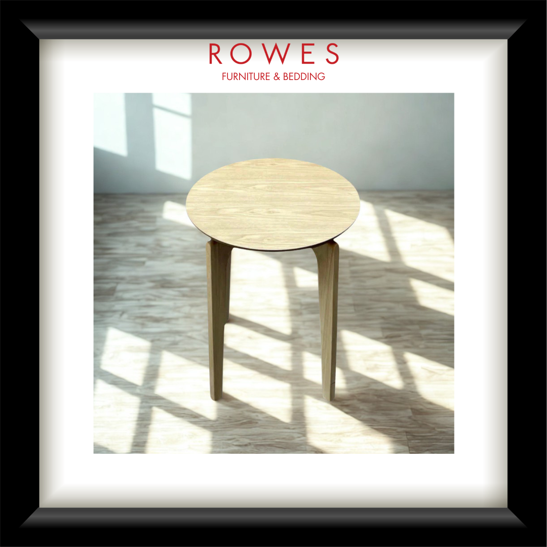 A lamp table in a well lit room on a timber floor with the Rowes branding