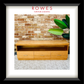 A framed product photo of a light wood bench or low cabinet with three drawers and open shelving, set against a brick wall with a green plant. The image is matted with a white border and a black frame, with the text 'ROWES FURNITURE & BEDDING' at the top.