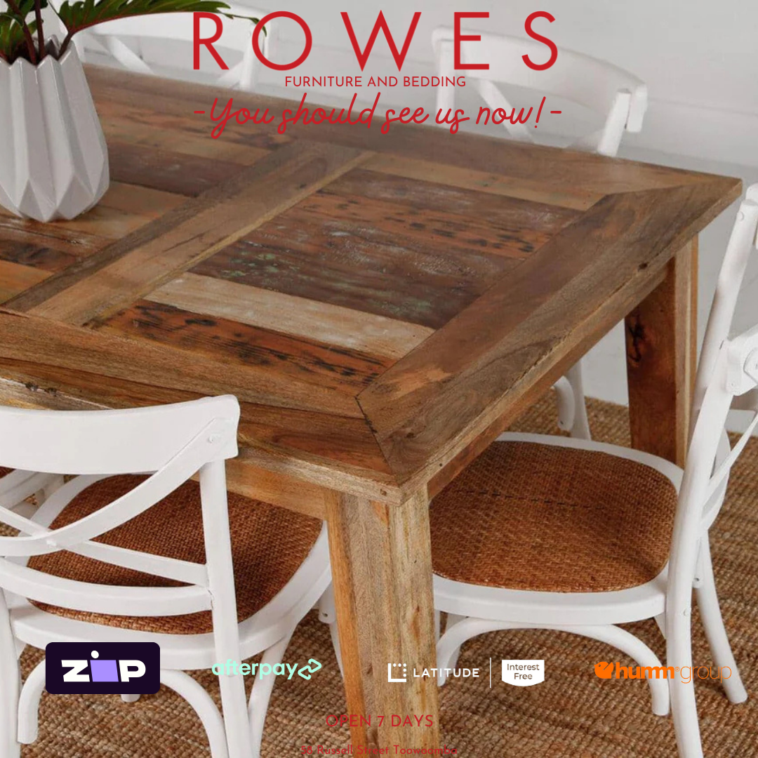 Wooden dining table with white chairs on a textured floor, featuring ROWES furniture branding.