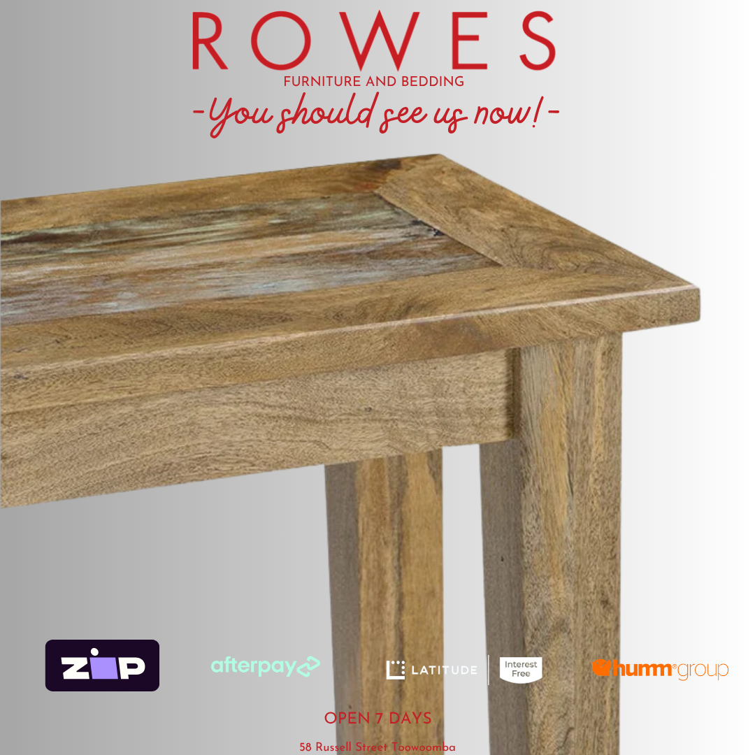Wooden table with promotional text and logos for ROWES furniture and bedding on a gray background.