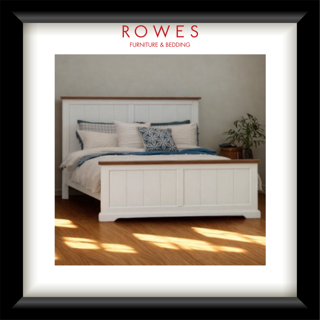 White bed with wooden accents in a room with sunlight filtering through a window, featuring 'Rowes Furniture & Bedding' branding.