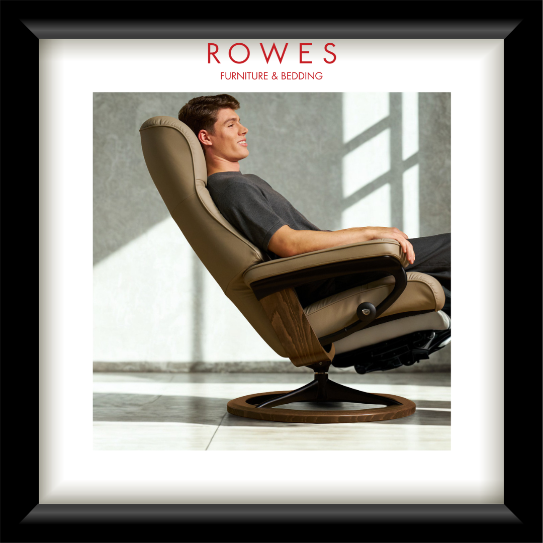 Man relaxing in a modern recliner chair with 'Rowes Furniture & Bedding' branding.