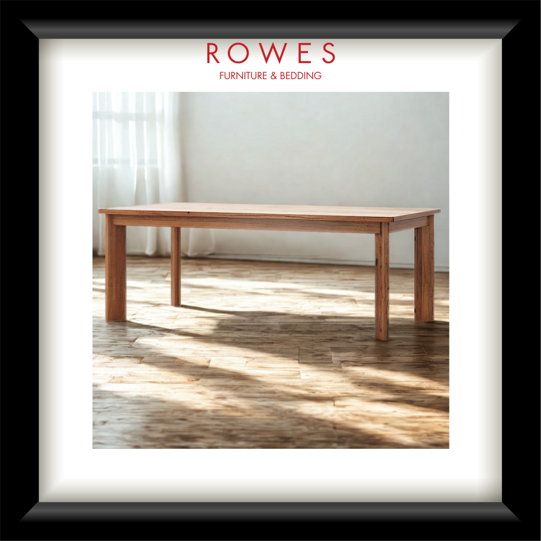 Wooden table in a room with sunlight filtering through curtains, branded 'Rowes Furniture & Bedding'.