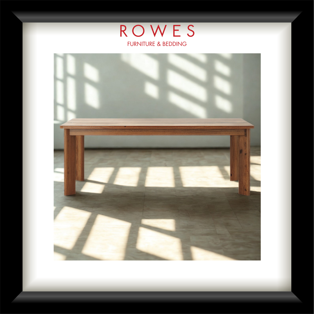 Wooden table in a room with sunlight filtering through windows, branded 'Rowes Furniture & Bedding'.