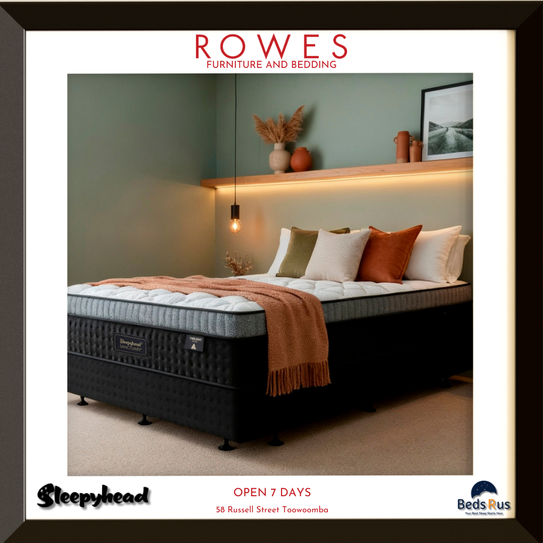Bed with pillows and a blanket in a bedroom setting, featuring Rowes Furniture and Bedding branding.