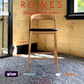 Wooden bar stool in a room with a window and 'Rowes' branding.