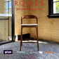 Wooden chair on a gray rug with 'Rowes' branding and promotional text.