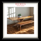 Wooden dining table with bench in a room with sunlight streaming through a window, branded 'Rowes Furniture & Bedding'.
