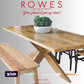 Wooden dining table with bench and potted plant on a gray background, featuring 'Rowes' furniture and bedding advertisement.