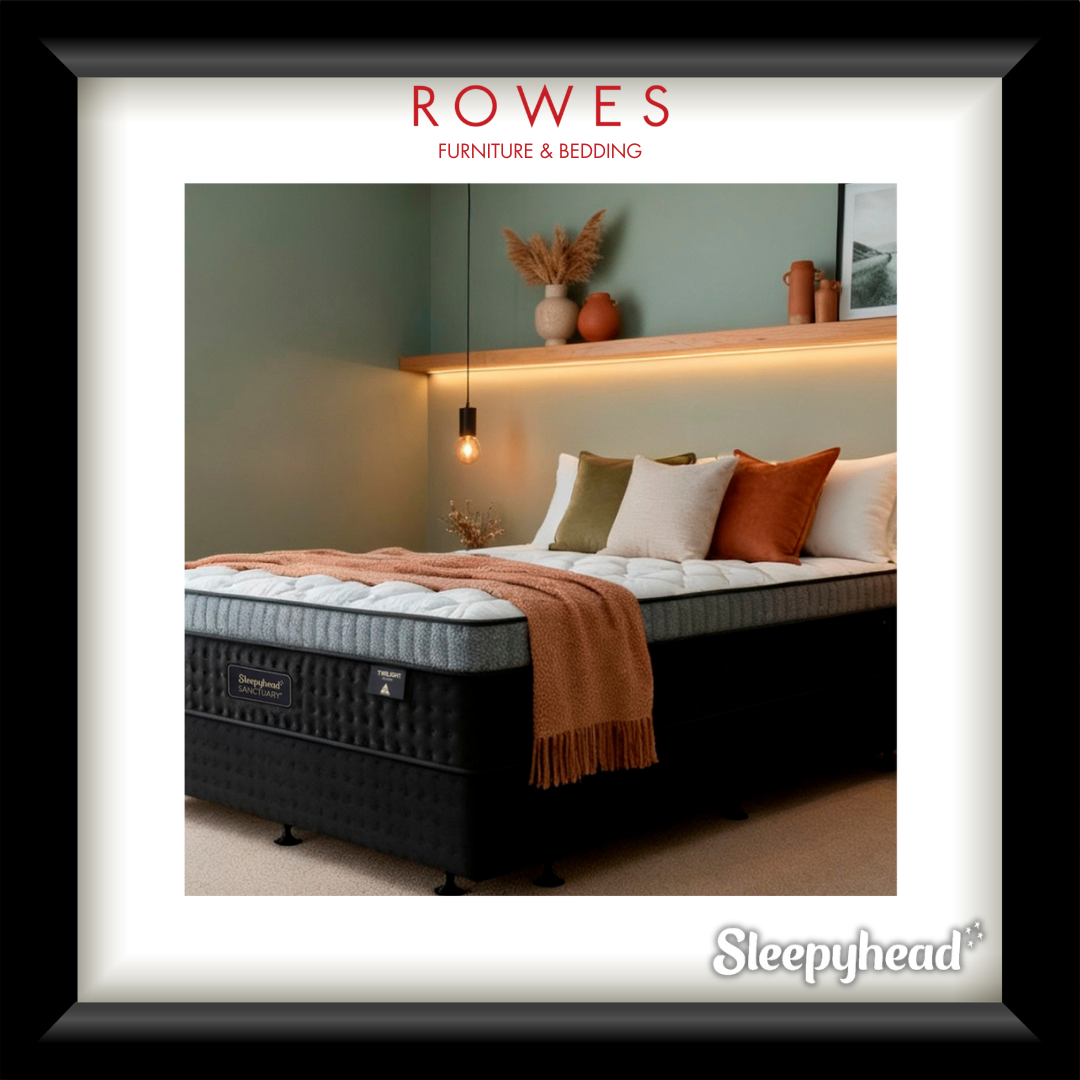 Bed with pillows and a blanket in a bedroom setting, featuring Rowes Furniture & Bedding branding.