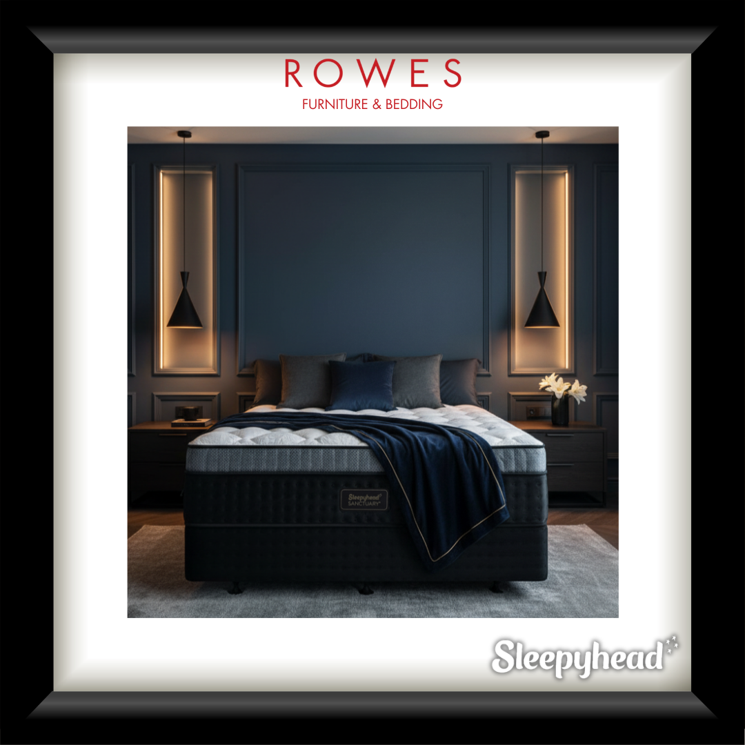 Bedroom setup with a mattress and pillows, featuring Rowes Furniture & Bedding branding.