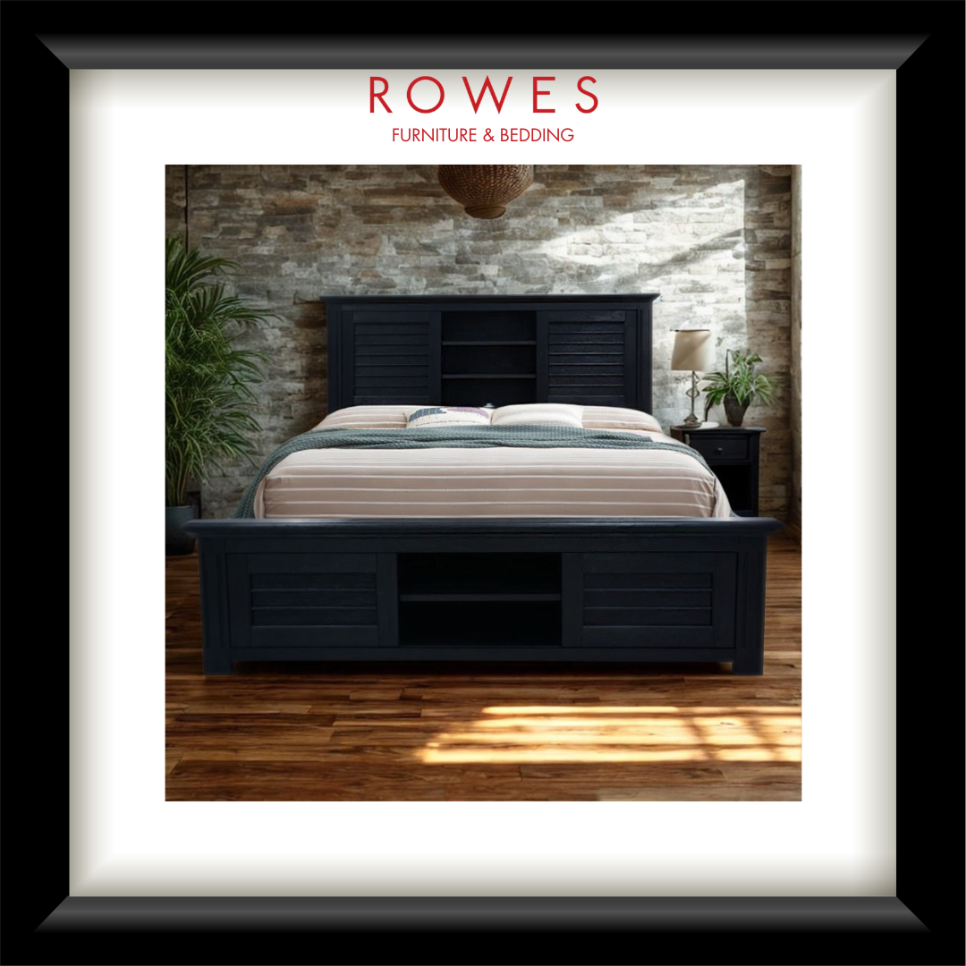Dark wooden bed with white bedding in a room with stone wall and wooden floor, featuring 'Rowes Furniture & Bedding' logo.