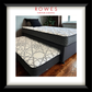 Gray upholstered bed with patterned mattress in a room setting, featuring 'Rowes Furniture & Bedding' logo.