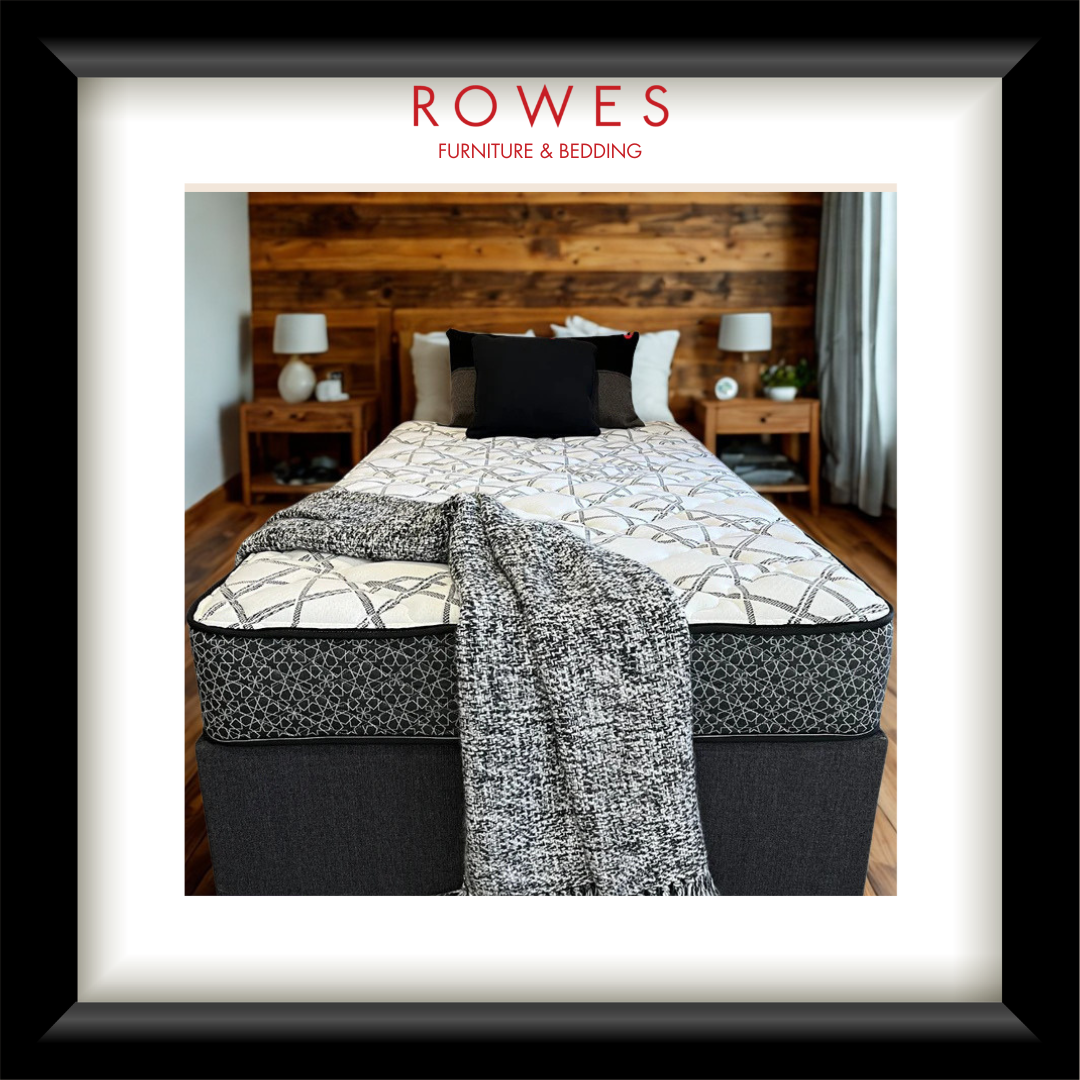 Bed with patterned bedding and a blanket in a bedroom setting, featuring 'Rowes Furniture & Bedding' logo.