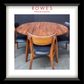 A framed product photo of a round wooden dining table with four matching chairs featuring black upholstered seats, presented with a white mat and black frame. The brand name 'ROWES FURNITURE & BEDDING' is printed at the top of the photo.